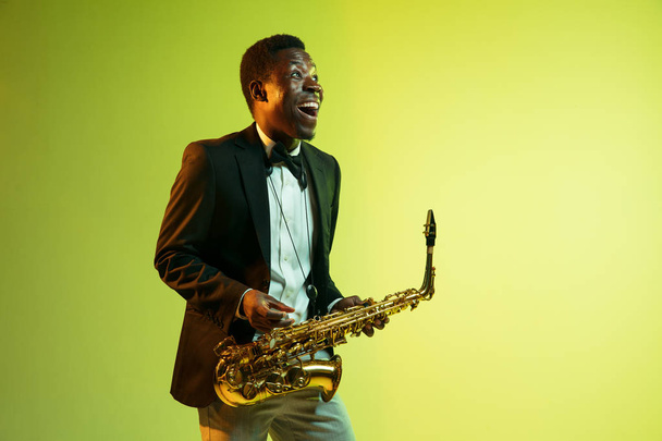 Young african-american jazz musician playing the saxophone - Photo, image