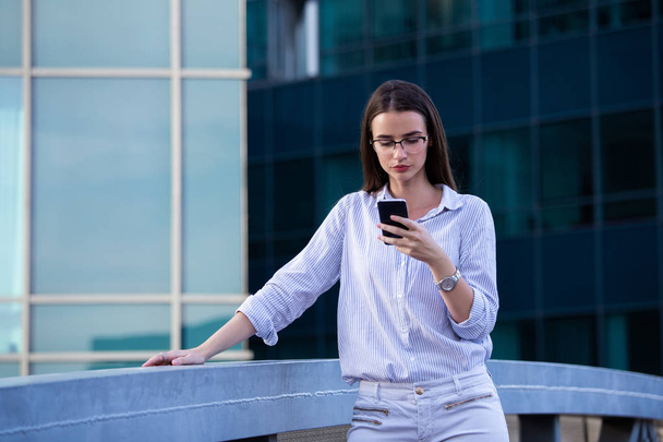 Executive kobieta biznesu patrząc na smartfon komórkowy w str - Zdjęcie, obraz