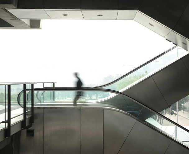 Hombre de negocios se mueven en escaleras mecánicas
 - Foto, imagen