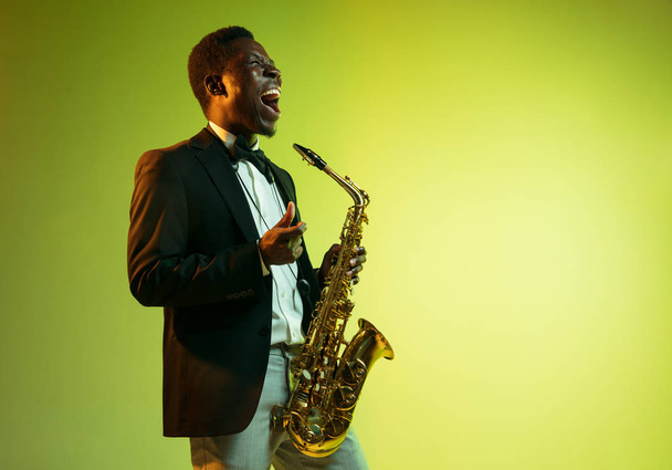 Młody afro-amerykański muzyk jazzowy grający na saksofonie - Zdjęcie, obraz