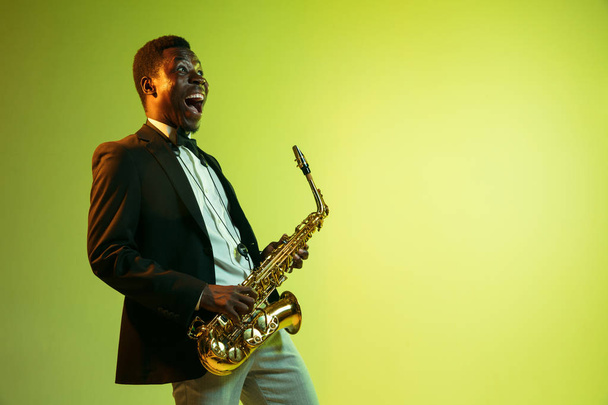 Young african-american jazz musician playing the saxophone - Foto, immagini