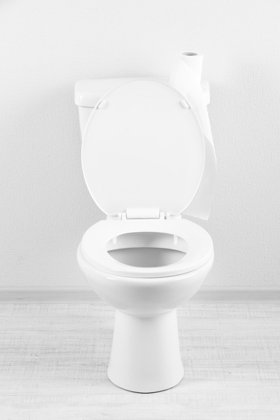 Белая унитаз с туалетной бумагой в ванной комнате
 - Фото, изображение