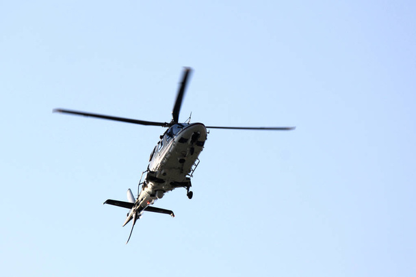 Hermoso helicóptero moderno en vuelo aislado contra el cielo
 - Foto, imagen