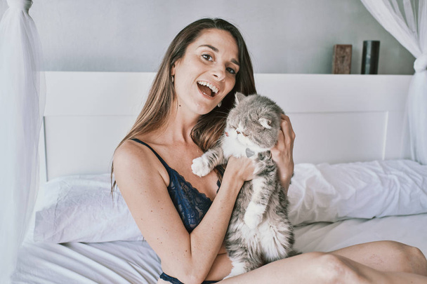 una mujer sexy en ropa interior con su gato exótico
 - Foto, imagen