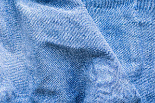Wrinkles on blue jeans, denim, texture. top view close up. - Photo, Image