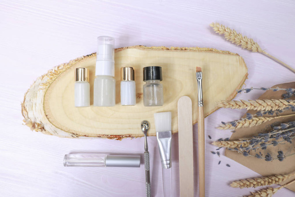 Cosmetology tools: aesthetics, eyebrow tattoo brush, scissors, cream tube, jar on a light background - Photo, Image