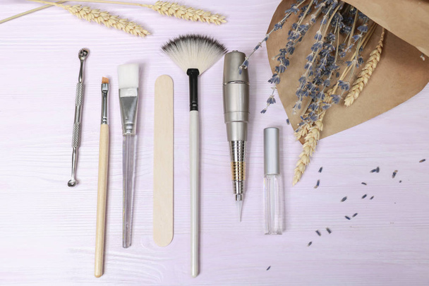 Kosmetologie-Werkzeuge: Ästhetik, Augenbrauen-Tätowierpinsel, Schere, Cremetubus, Glas auf hellem Hintergrund - Foto, Bild