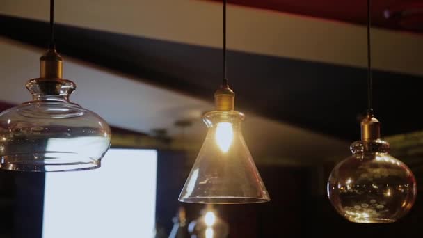 Vintage and retro yellow light bulb hanging over dark background in cafe at night. Many luxury light lamp decorative industrial loft style in bistro and restaurant. - Footage, Video