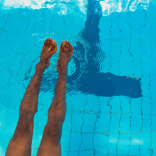 adult African American man's legs underwater in swimming pool - Foto, imagen