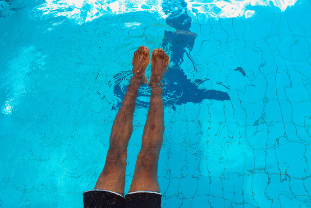 volwassen Afro-Amerikaanse man benen onderwater in het zwembad - Foto, afbeelding
