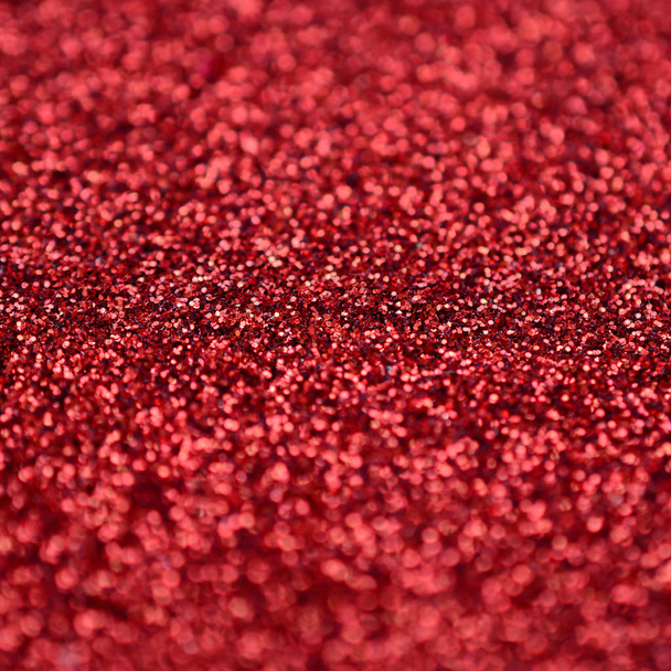 Lantejoulas decorativas vermelhas carmesim. Imagem de fundo com luzes bokeh brilhantes de pequenos elementos
 - Foto, Imagem