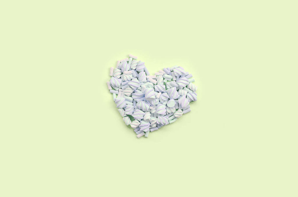 Colorful marshmallow laid out on lime and pink paper background. pastel creative textured heart - Photo, Image