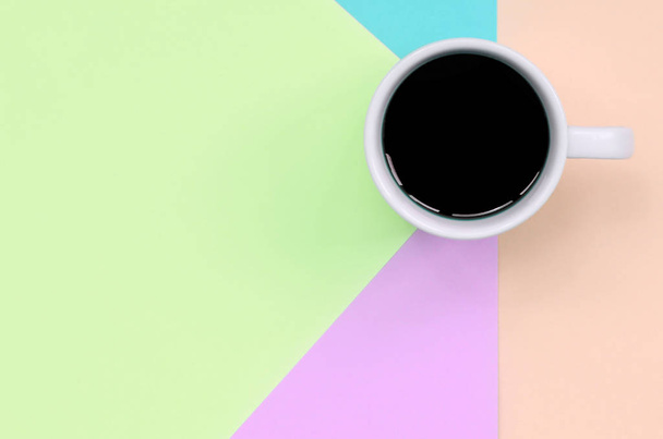 Pequeña taza de café blanco en el fondo de textura de la moda pastel rosa, azul, coral y papel de colores de cal
 - Foto, imagen