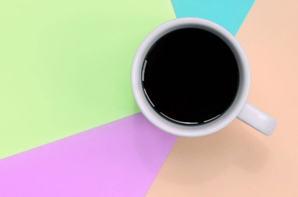 Pequeña taza de café blanco en el fondo de textura de la moda pastel rosa, azul, coral y papel de colores de cal
 - Foto, Imagen