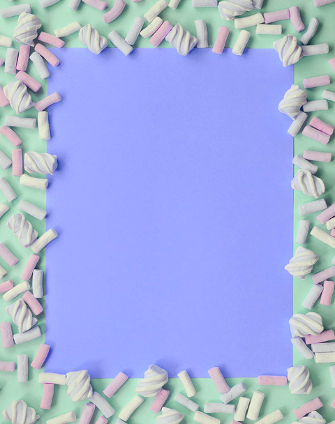 Värikäs vaahtokarkki aseteltu vihreä ja lila paperi tausta
 - Valokuva, kuva