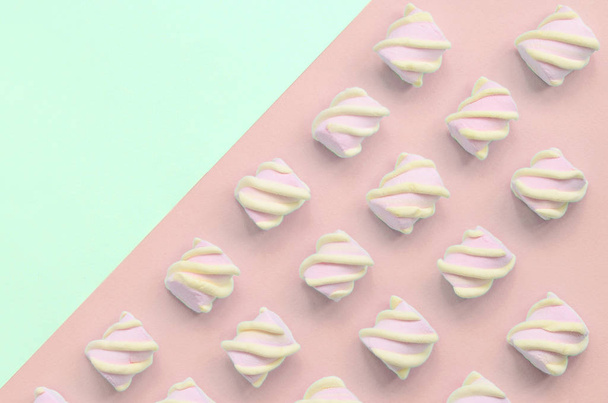 Πολύχρωμα ζαχαρωτά που βρίσκονται σε τιρκουάζ και ροζ χαρτί φόντο - Φωτογραφία, εικόνα