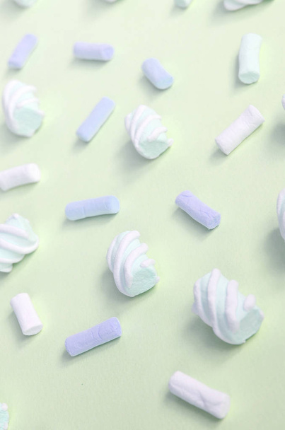 Colorful marshmallow laid out on lime paper background. pastel creative textured pattern - Photo, Image