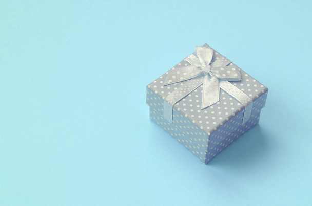 Pequeña caja de regalo azul se encuentran en el fondo de textura de papel de color azul pastel de moda
 - Foto, imagen