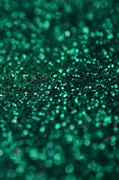 A huge amount of green decorative sequins. Background image with shiny bokeh lights from small elements - Photo, Image