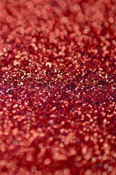 Szkarłatny czerwony dekoracyjne cekiny. Obraz tła z błyszczącymi światłami bokeh z małych elementów - Zdjęcie, obraz
