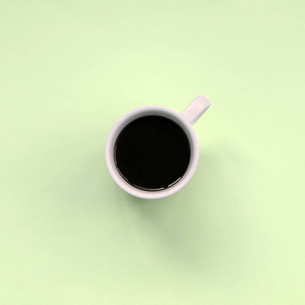 Pequeña taza de café blanco en el fondo de textura de la moda pastel papel de color lima
 - Foto, Imagen