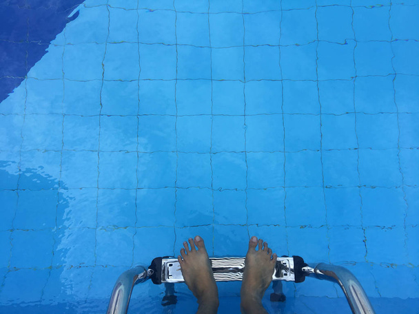 męskich stóp w na drabinie basen - Zdjęcie, obraz