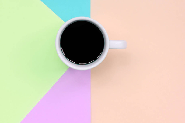 Small white coffee cup on texture background of fashion pastel pink, blue, coral and lime colors paper - Photo, Image