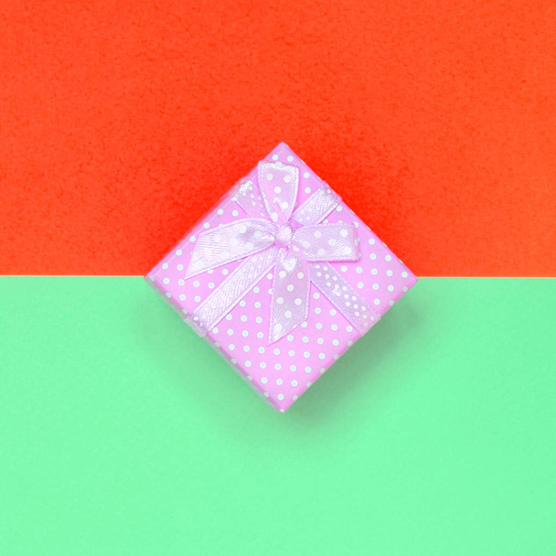 Piccola scatola regalo rosa si trovano su sfondo texture di carta turchese pastello moda e colori rossi
 - Foto, immagini