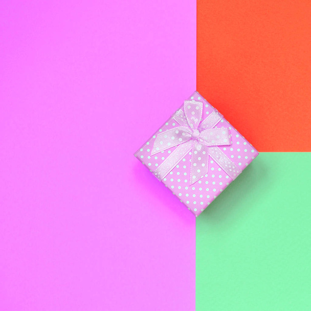 Pequeña caja de regalo rosa se encuentran en el fondo de textura de la moda pastel turquesa, rojo y rosa colores papel
 - Foto, imagen