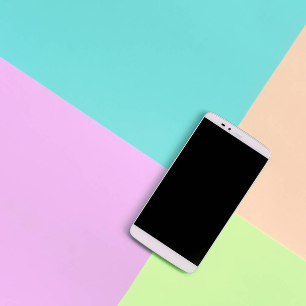 Smartphone moderno con pantalla negra sobre fondo de textura de colores pastel de moda rosa, azul, coral y lima
 - Foto, imagen