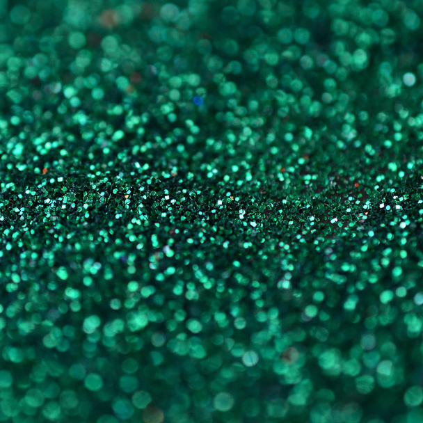 Una gran cantidad de lentejuelas decorativas verdes. Imagen de fondo con luces bokeh brillantes de pequeños elementos
 - Foto, imagen