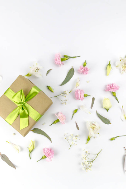 Blütenkomposition. Geschenke und Rosenblumen auf weißem Holztisch. Frauentag. flache Lage, Draufsicht, Kopierraum - Foto, Bild