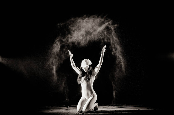 Дівчина з борошном на тілі розтягує руки кинутим борошном на чорно-білому тлі чорно-біле зображення
 - Фото, зображення