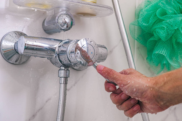 Person hand using faucet in shower. - Fotó, kép
