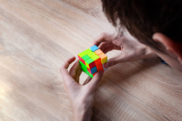 Young men holding Rubik's cube and playing with it - 写真・画像