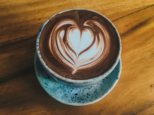 Kakao lub czekolada pić z miłością latte w kubku izolowane na drewnianym tle, widok z góry - Zdjęcie, obraz