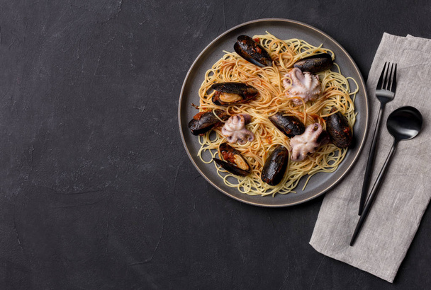 Spaghetti with mussels and octopus in gray plate - Photo, image