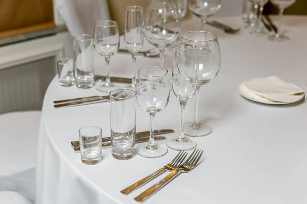 Szép asztal beállítás edények egy fél, esküvői fogadás vagy más ünnepi esemény. Üres üvegedények és evőeszköz a kiszolgáltott eseményhez. Horizontális fénykép - Fotó, kép