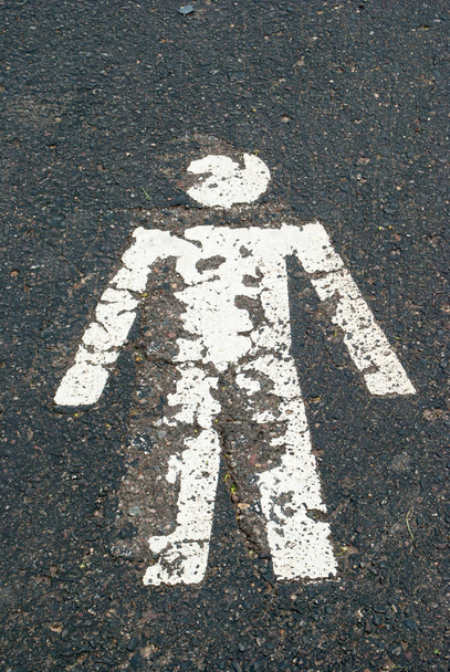 Voetgangers bord met persoon op asfalt weg - Foto, afbeelding