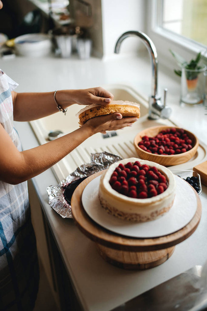 Girl baker prepares a delicious berries cheesecake - Fotoğraf, Görsel