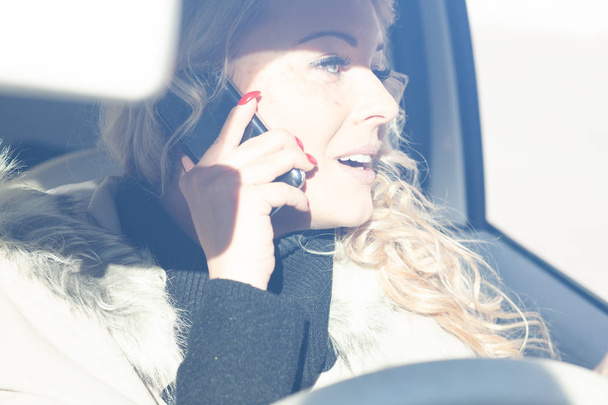 junge Autofahrerin chattet auf ihrem Handy - Foto, Bild