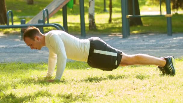Atletische man bodybuilder doen een push-ups op het gras - Video