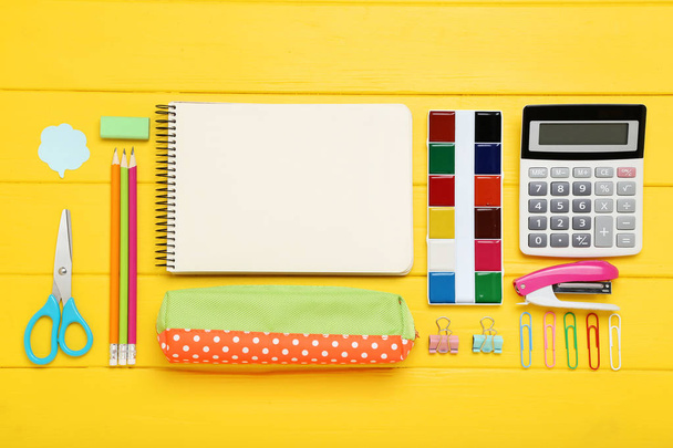 School supplies with blank sheet of paper on yellow wooden table - Photo, image