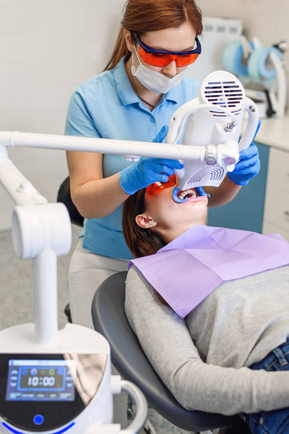 Teeth whitening procedure for pretty happy female patient in a dental clinic - Foto, immagini