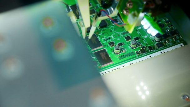 Máquina de fábrica no trabalho: Placa de circuito impresso sendo montada com braço robótico automatizado, tecnologia montada na superfície conectando microchips à placa-mãe. Macro imagens de close-up
. - Filmagem, Vídeo