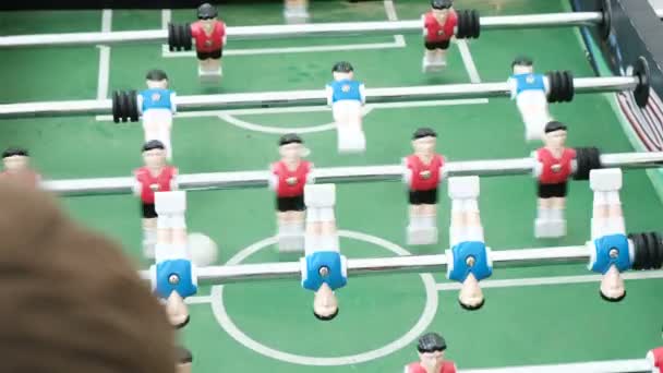 Люди играют в настольный футбол с красными и синими игроками
 - Кадры, видео