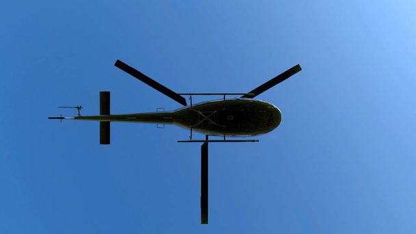 Rendement 3D. Vue à faible angle de vol hélicoptère en métal noir sur fond de ciel bleu
. - Photo, image