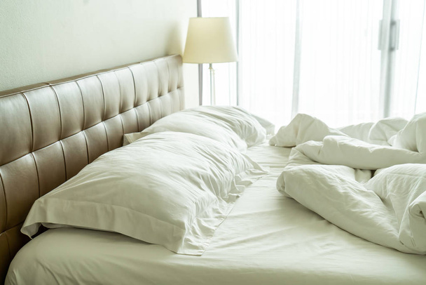 Messy bed with white pillow and blanket on bed  - Photo, Image