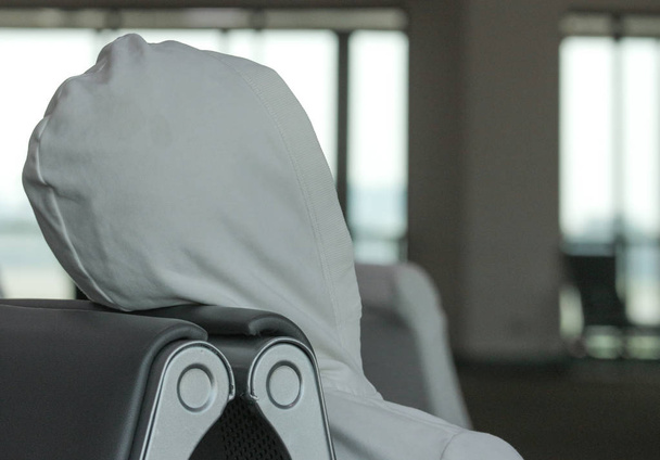 istuimella lepää valkoinen kangasmies, joka odottaa läpikulkulentoa lentokentän terminaalissa
. - Valokuva, kuva