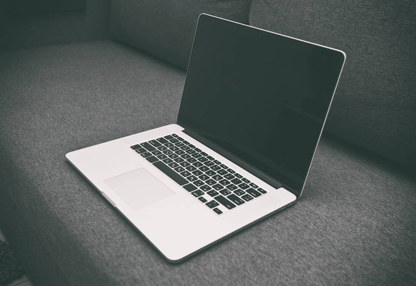 A modern laptop az új szürke kanapé - Fotó, kép